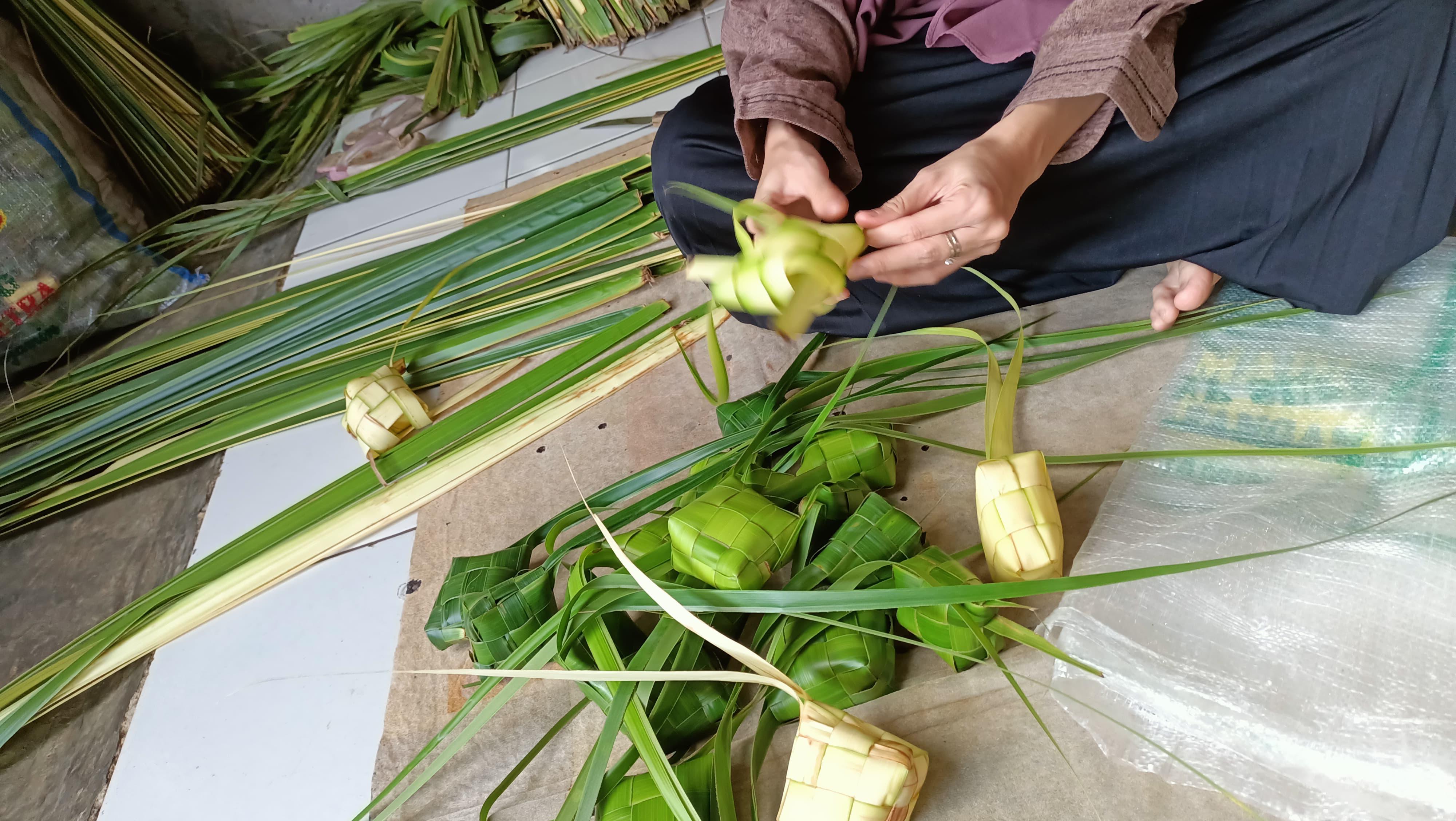 Potret saat warga tengah menganyam ketupat