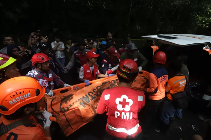 Petugas gabungan berusaha mengevakuasi korban terimbun longsor di Jalan Raya Sumber Brantas-Pacet, Cangar, Kabupaten Mojokerto, Jawa Timur, Jumat (4/4/2025) siang.
