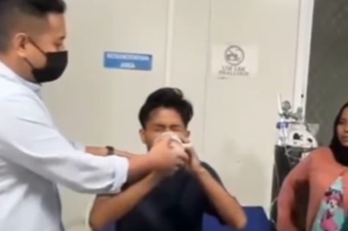 Seorang pria yang merasa kesakitan saat disuruh minum segelas air setelah virus rabies menjalar di tubuhnya.