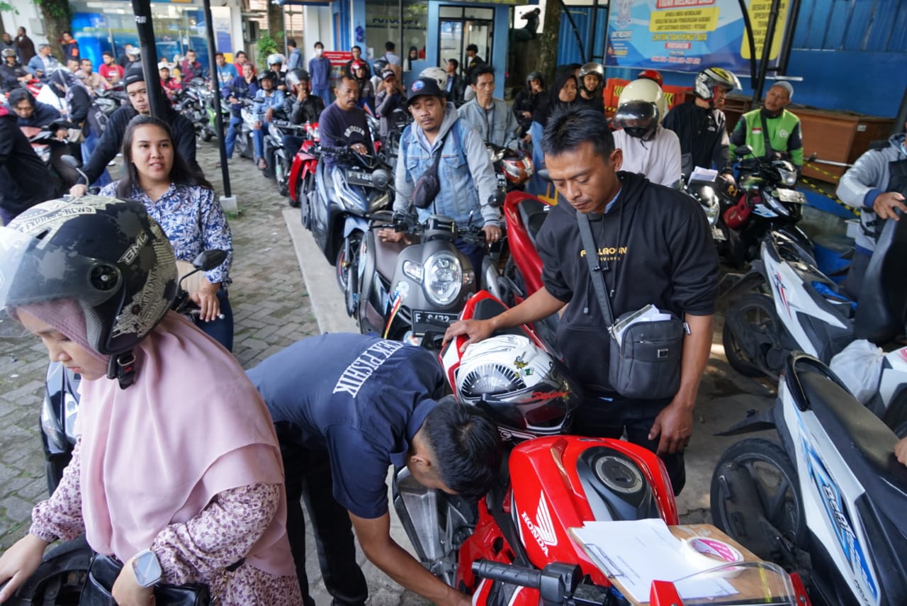 Sejumlah warga dengan sepeda motor menunggu antrean pendaftaran cek fisik kendaraan dalam program pemutihan pajak kendaraan di Samsat Kota Bogor.