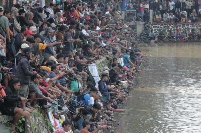 Ribuan warga mengikuti mancing massal gratis di Cibinong, Kabupaten Bogor, MInggu (13/4/2025).