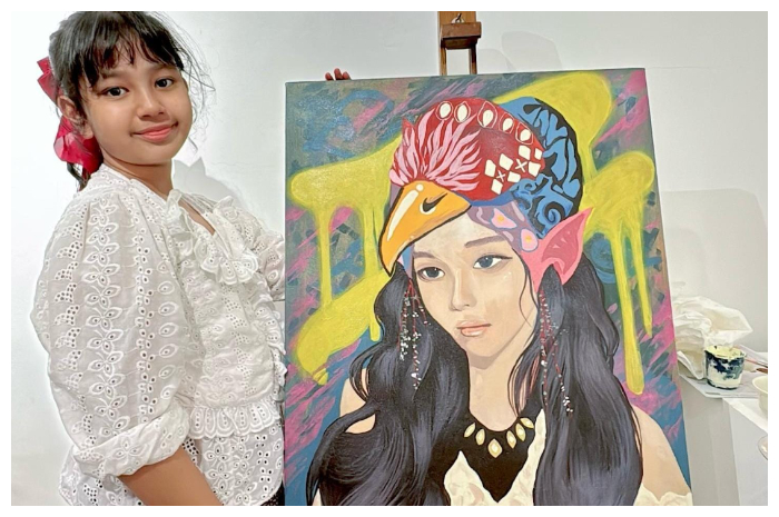 Pelukis cilik asal Kota Bogor, Maluka Abiya bersama karyanya yang tampil di Pameran Perempuan Melukis di Jakarta.