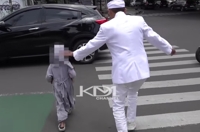 Gubernur Jawa Barat, Dedi Mulyadi mengawal bocah yang berjualan menyeberang jalan.