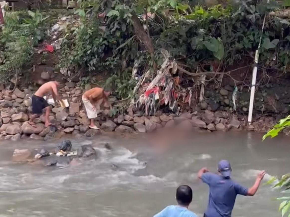 Warga saat menemukan seorang pria tanpa identitas diduga hanyut di Kali Ciluar, Kecamatan Sukaraja, Kabupaten Bogor.