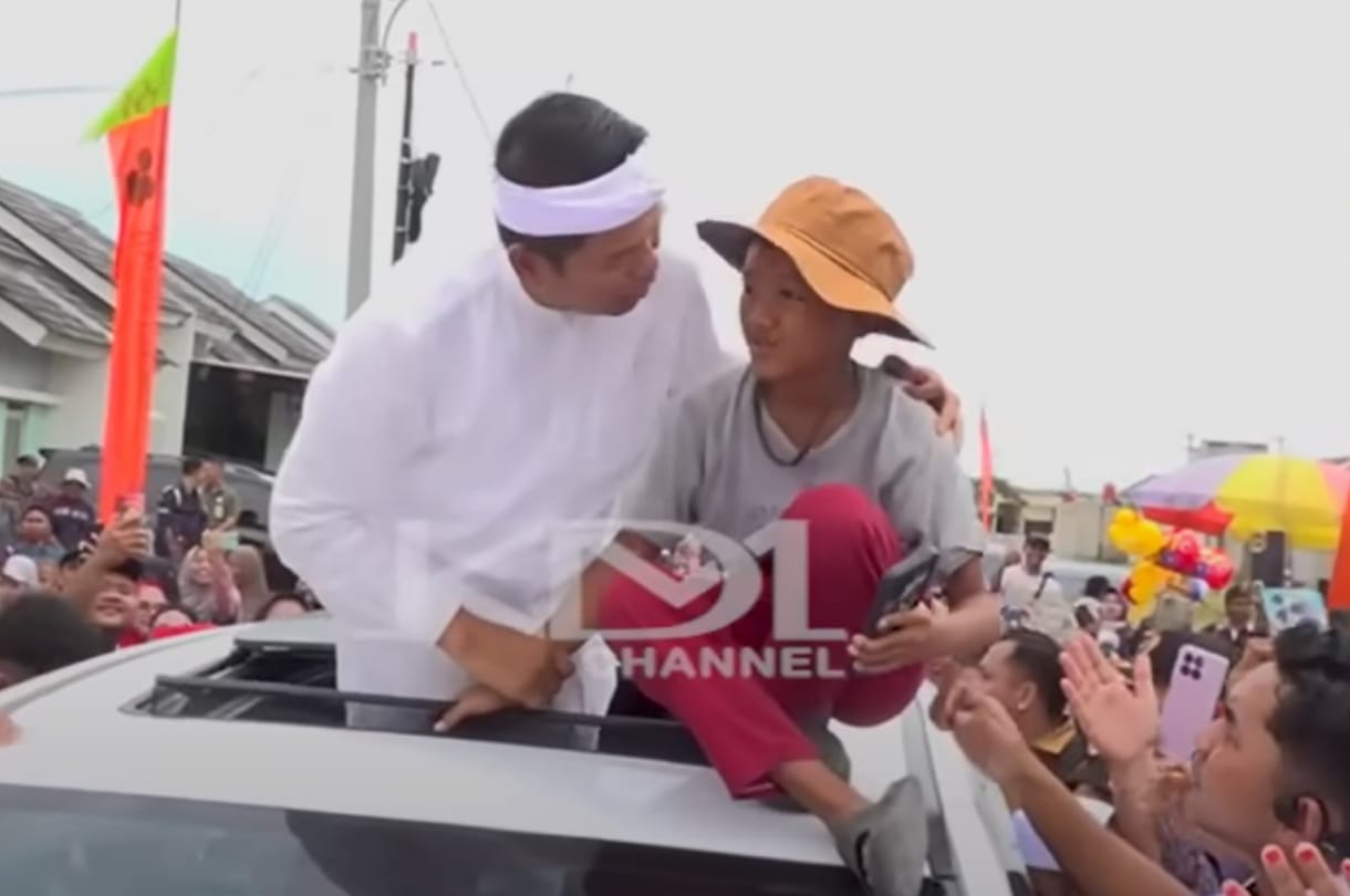 Gubernur Dedi Mulyadi bersama bocah asal Bekasi di atas mobil  di tengah lautan warga yang menyambutnya.