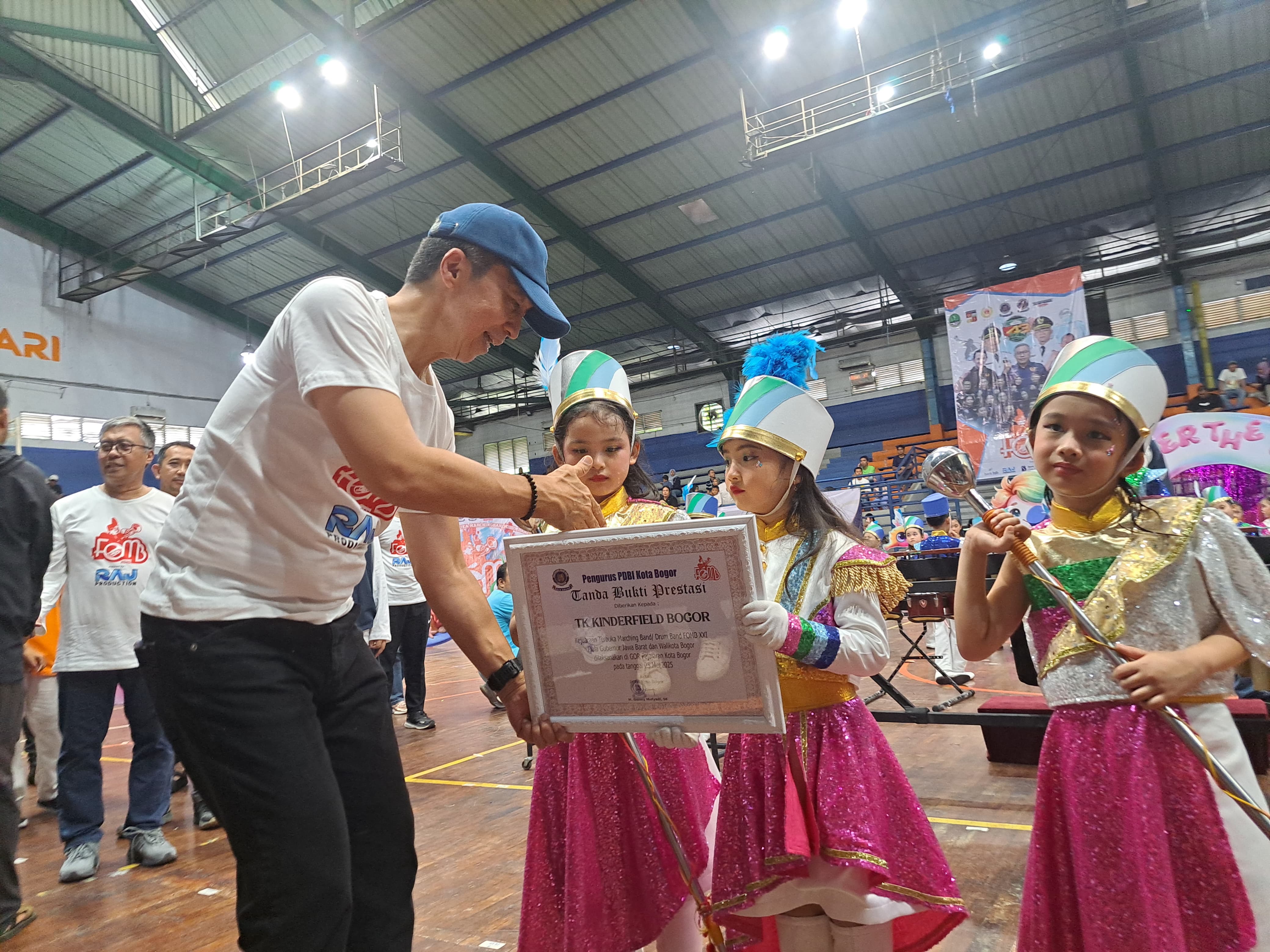 Wali Kota Bogor, Dedie A Rachim memberikan hadiah kepada pemenang Festival Open Marching yang digelar PDBI Kota Bogor di Gor Indoor Pajajaran, Minggu (25/5/2025).
