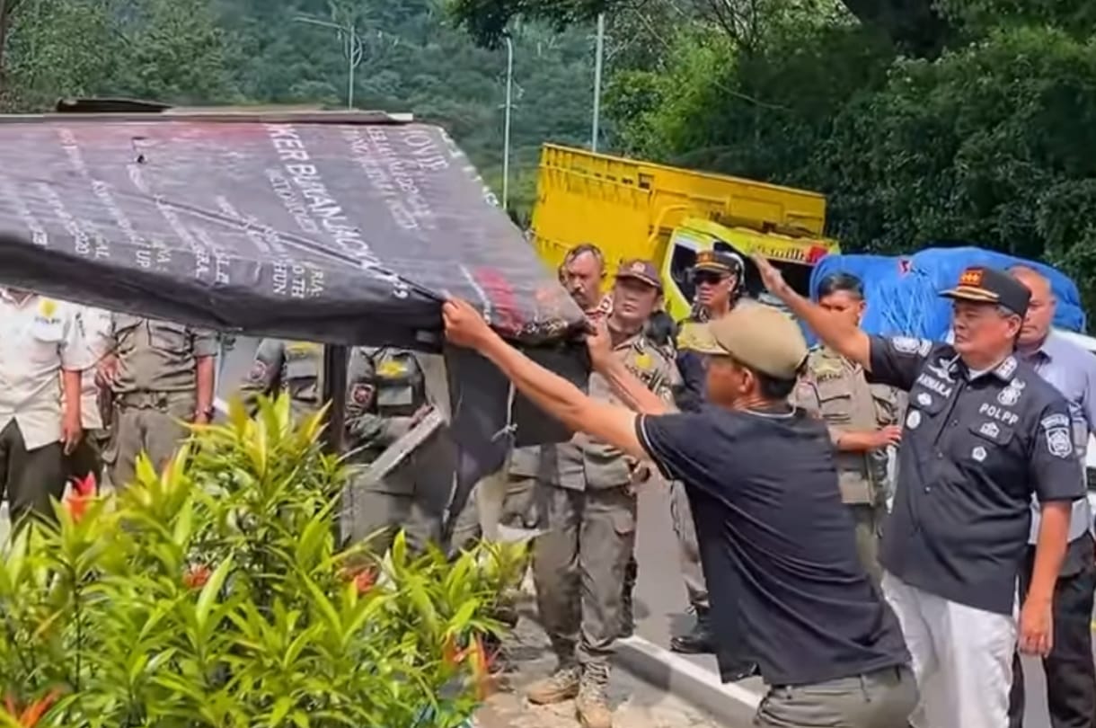 Petugas Satpol PP Bogor saat menertibkan lapak PKL di trotoar Puncak dalam giat penegakan Perda Ketertiban Umum.&nbsp;