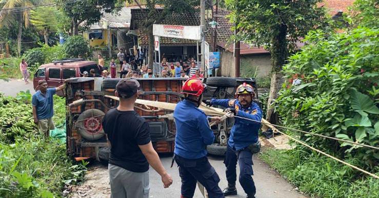 Mobil pickup bermuatan buah pisang terguling di Kampung Pabuaran, Desa Cimandala, Kecamatan Sukaraja, Kabupaten Bogor, Rabu (11/06/2025).