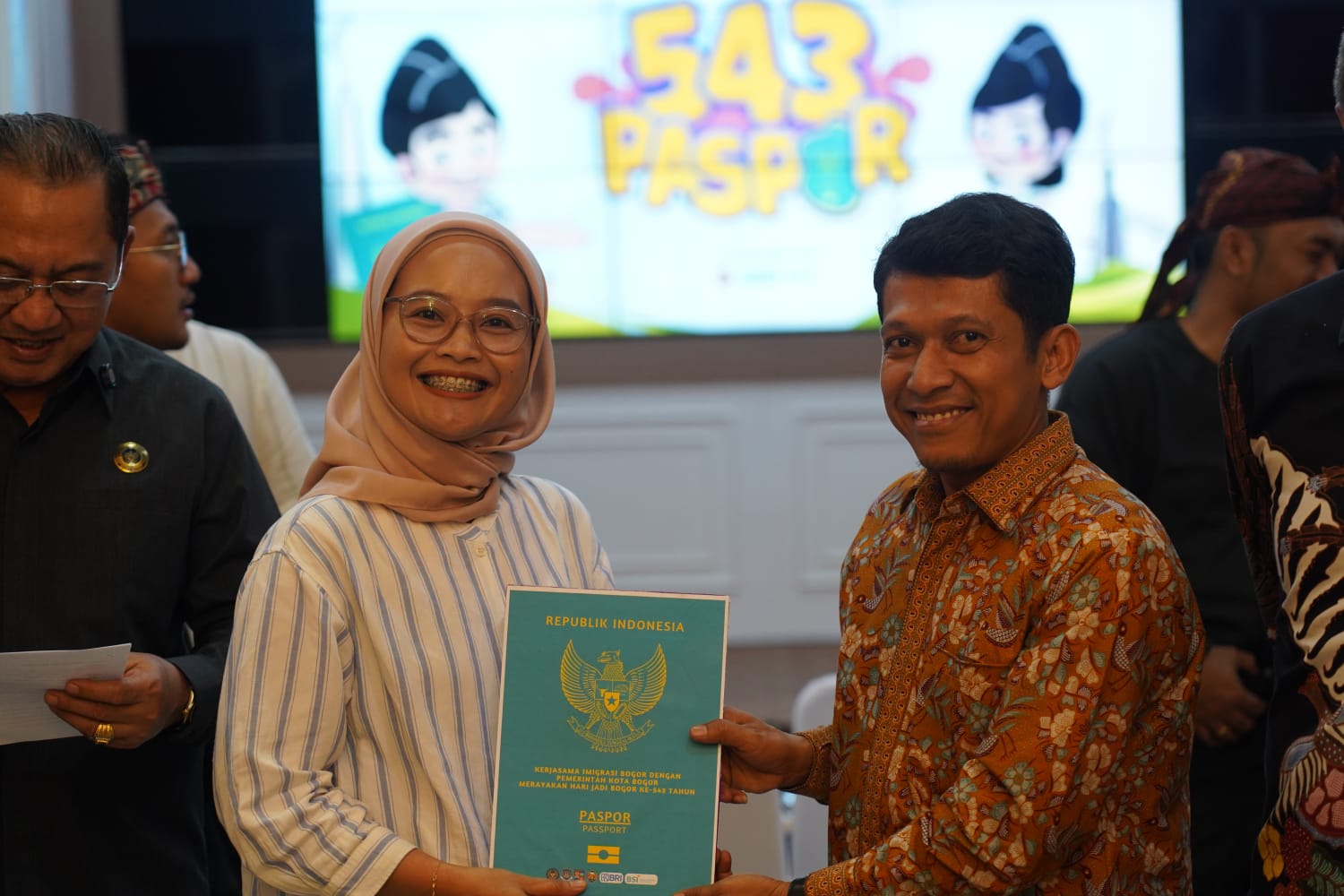 Wakil Ketua II DPRR Kota Bogor, Zenal Abidin saat menyerahkan secara simbolik paspor dalam layanan Paspor Simpatik.