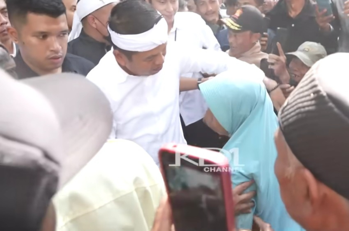 Gubernur Jawa Barat, Dedi Mulyadi menbantu warga berdiri saat kunjungan.