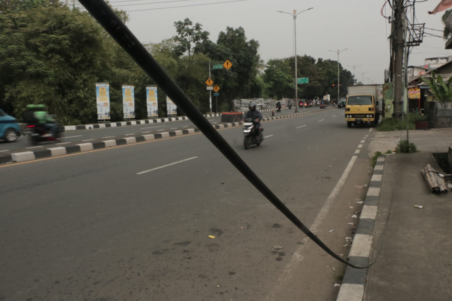 Sejumlah kabel jaringan menjuntai di Jalan Raya Bogor-Jakarta, hal itu membahayakan pengendara maupun pejalan kaki.