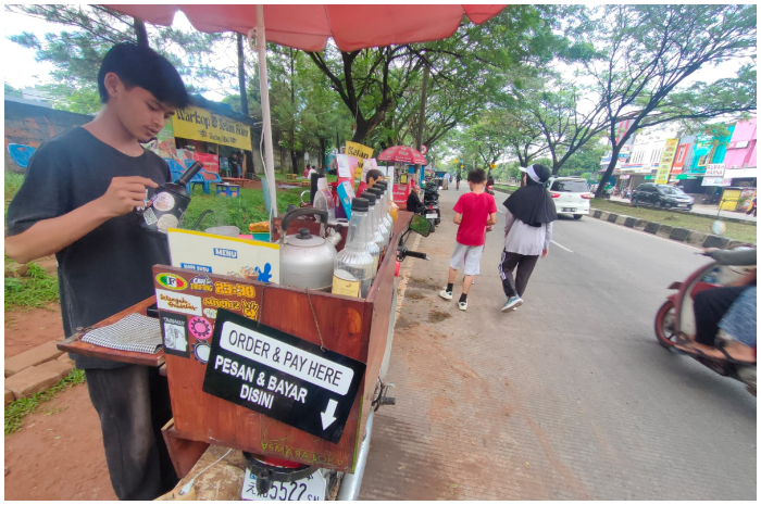Yuga barista Asmaraloka Street Coffee sedang menyeduh kopi  di kawasan GDC Kota Depok Minggu 29 Juni 2025.