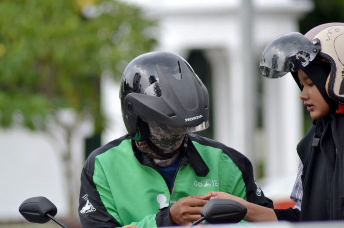 Pengendara ojol di Bogor saat mengantarkan penumpang. Kemnaker memberikan diskon 50 persen iuran JKK dan JKM.