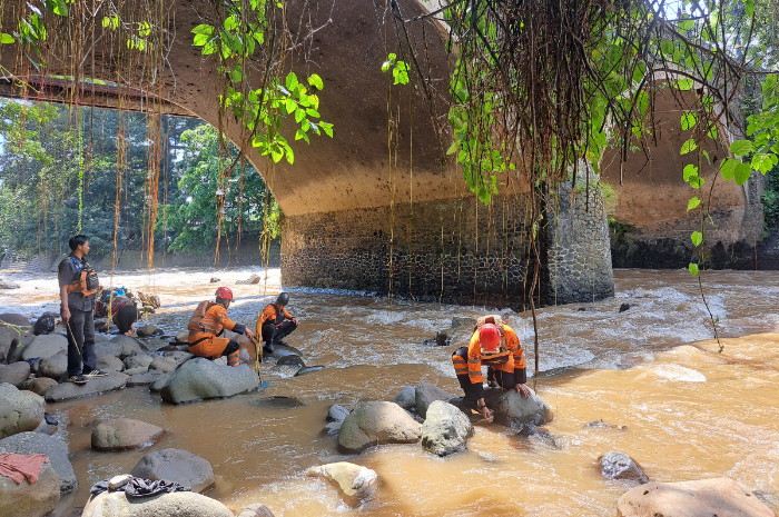 Personel BPBD Kota Bogor saat membantu mencari korban longor Megamendung di aliran Sungai Ciliwung.