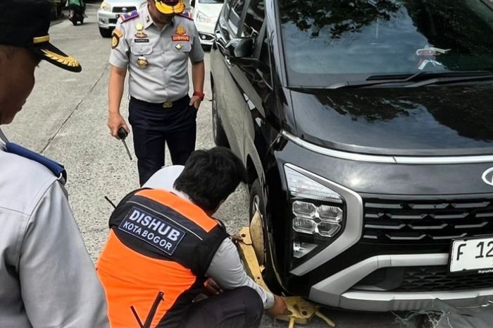Petugas Dishub Kota Bogor memberikan sanksi parkir liar di jalur sepeda.