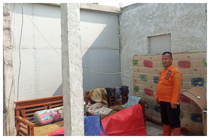 Petugas BPBD Kabupaten Bogor, saat mendatangi rumah warga yang rusak akibat pohon tumbang di Kelurahan Ciriung, Kecamatan Cibinong.