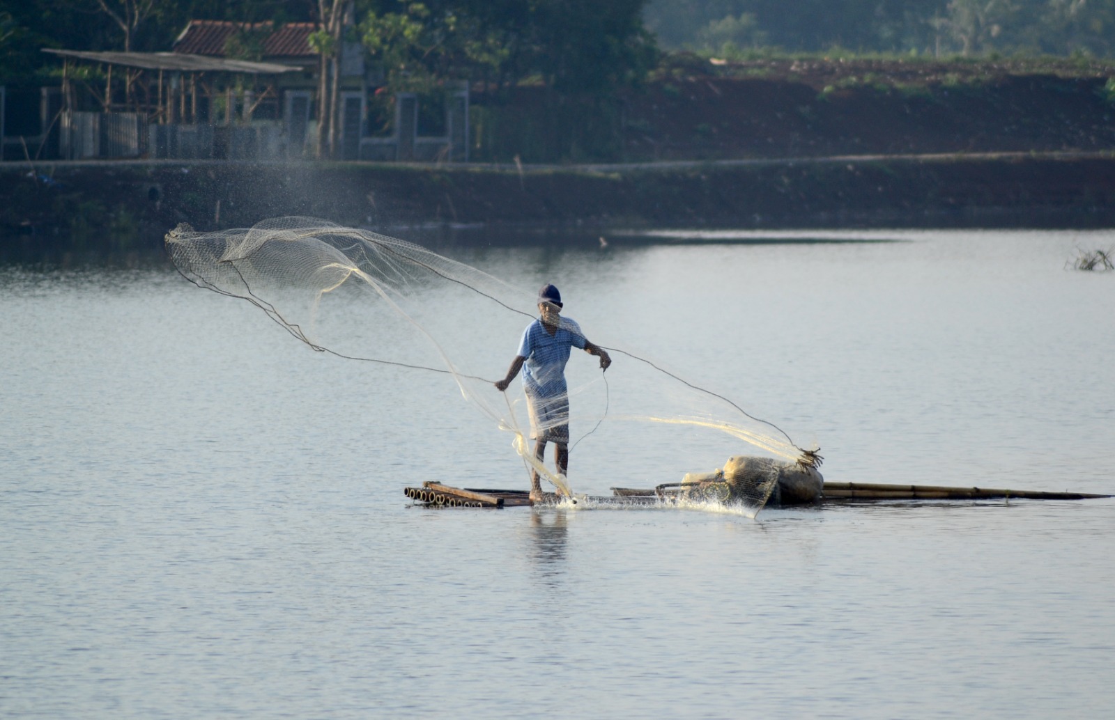 Warga me jaring ikan di Setu Cikaret, Cibinong, Kabupaten Bogor.