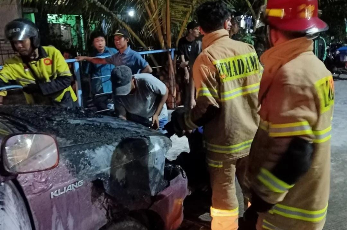 Petugas pemadam kebakaran (damkar) di lokasi mobil terbakar di Kota Depok.