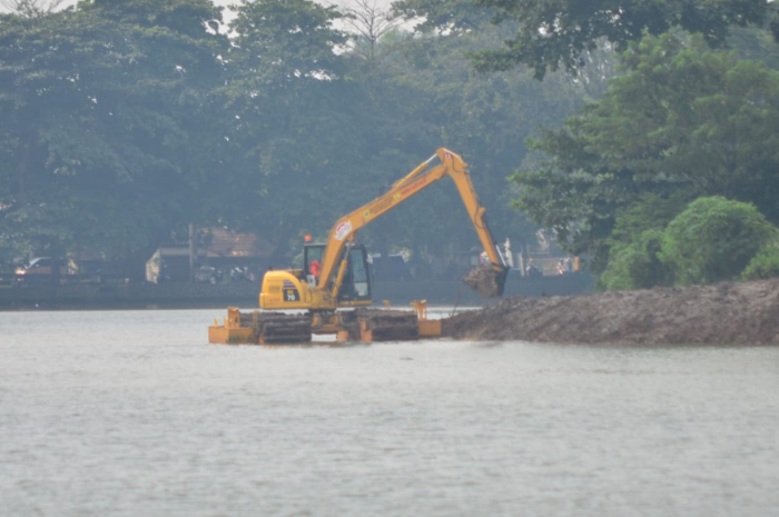 Satu unit excavator amfibi saat mebersihkan Situ Cibinong Plaza, Kabupaten Bogor.