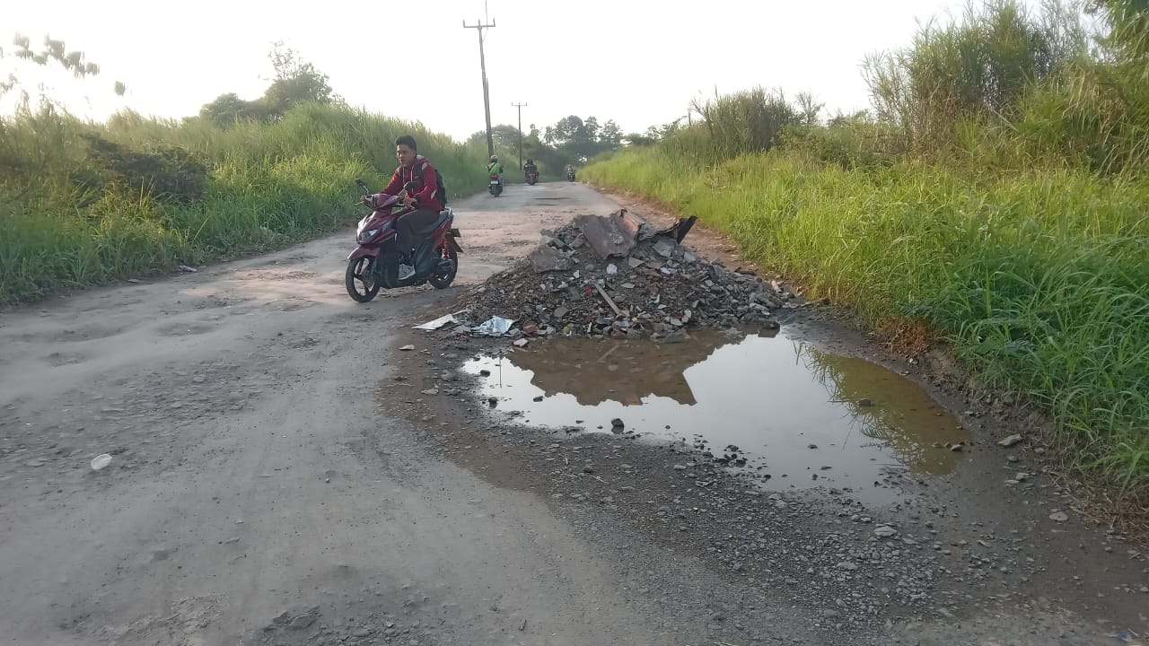 Jalan rusak di Desa Jampang, Gunungsindur, Kabupaten Bogor ditutupi bebatuan oleh warga.