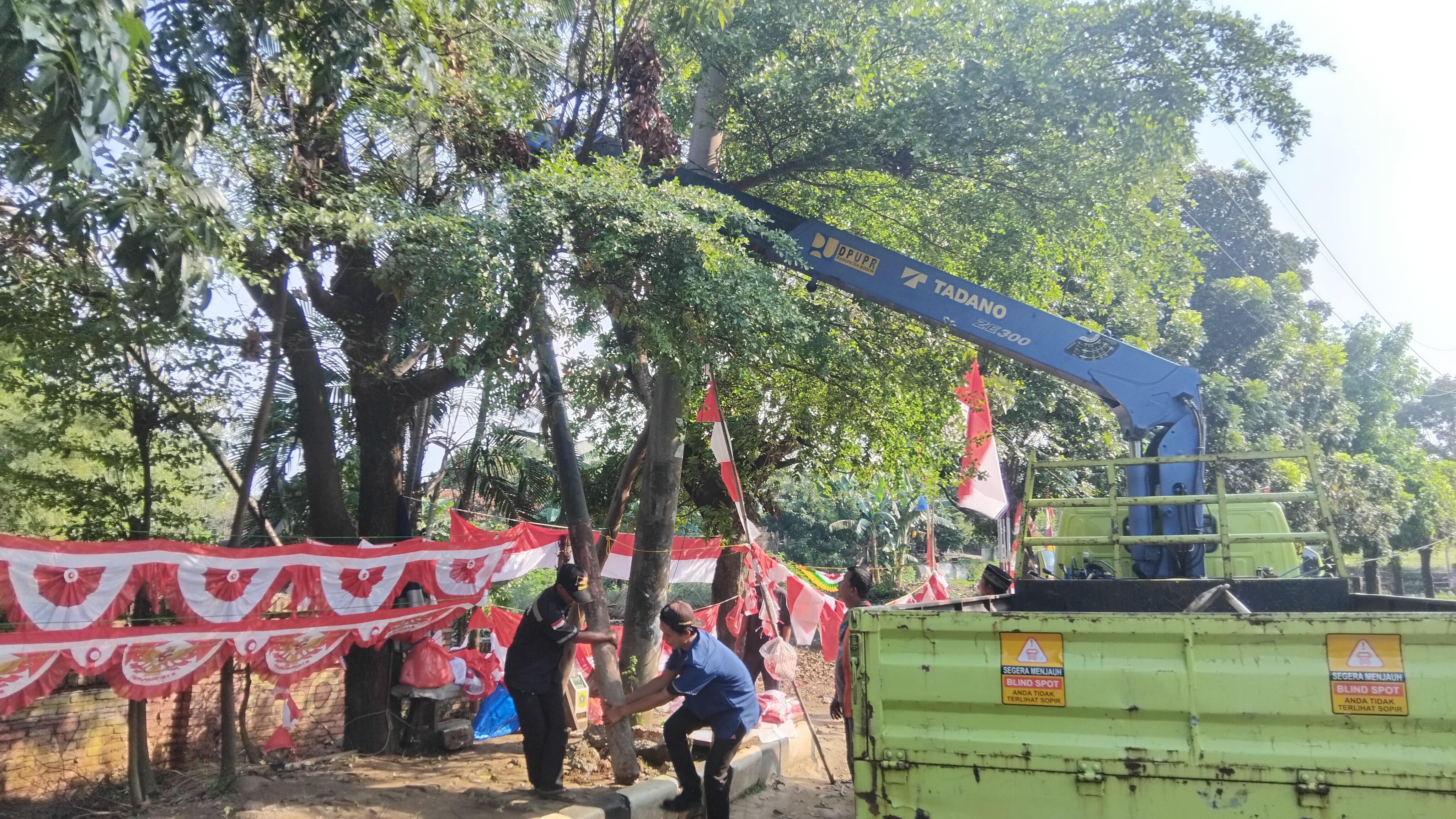 Petugas PUPR  Kabupaten Bogor sedang melakukan pencabutan tiang dan kabel FO di Simpang Sukahati, Kecamatan Cibinong, pada Jumat, 1 Agustus 2025.