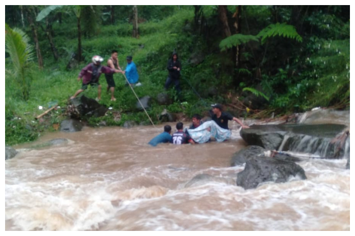 Warga mengevakuasi jasad korban yang terseret arus Sungai Cilember, Desa Megamendung, Kecamatan Megamendung, Kabupaten Bogor.