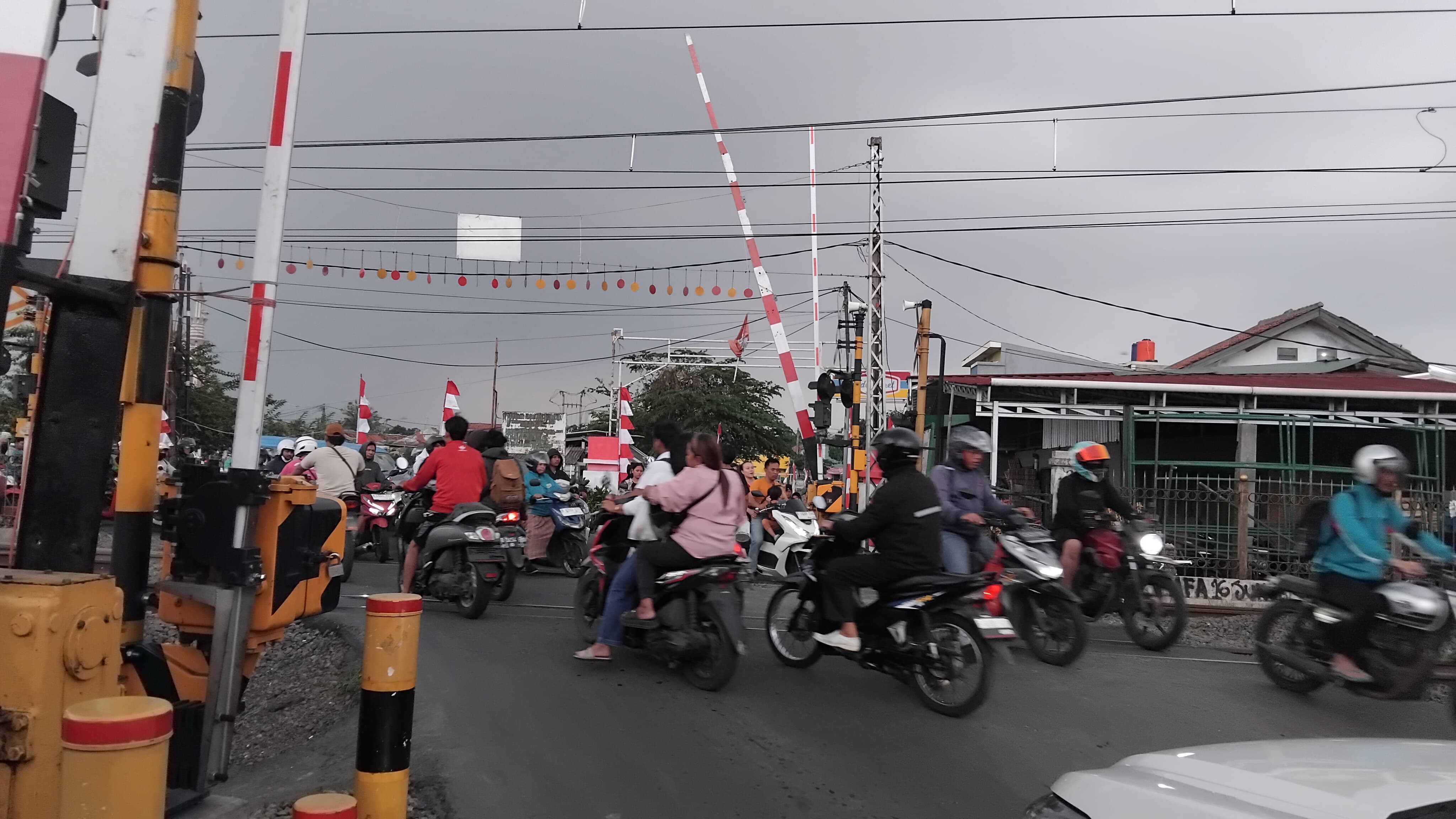 Para pengendara melintasi perlintasan kereta api di Kecamatan Bojong Gede, Kabupaten Bogor.