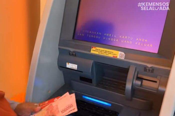 Masyarakat menerima pencairan bantuan sosial (bansos) melalui ATM.