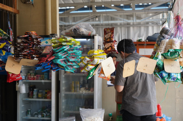 Petugas saat melakukan penyitaan rokok ilegal di sebuah warung.