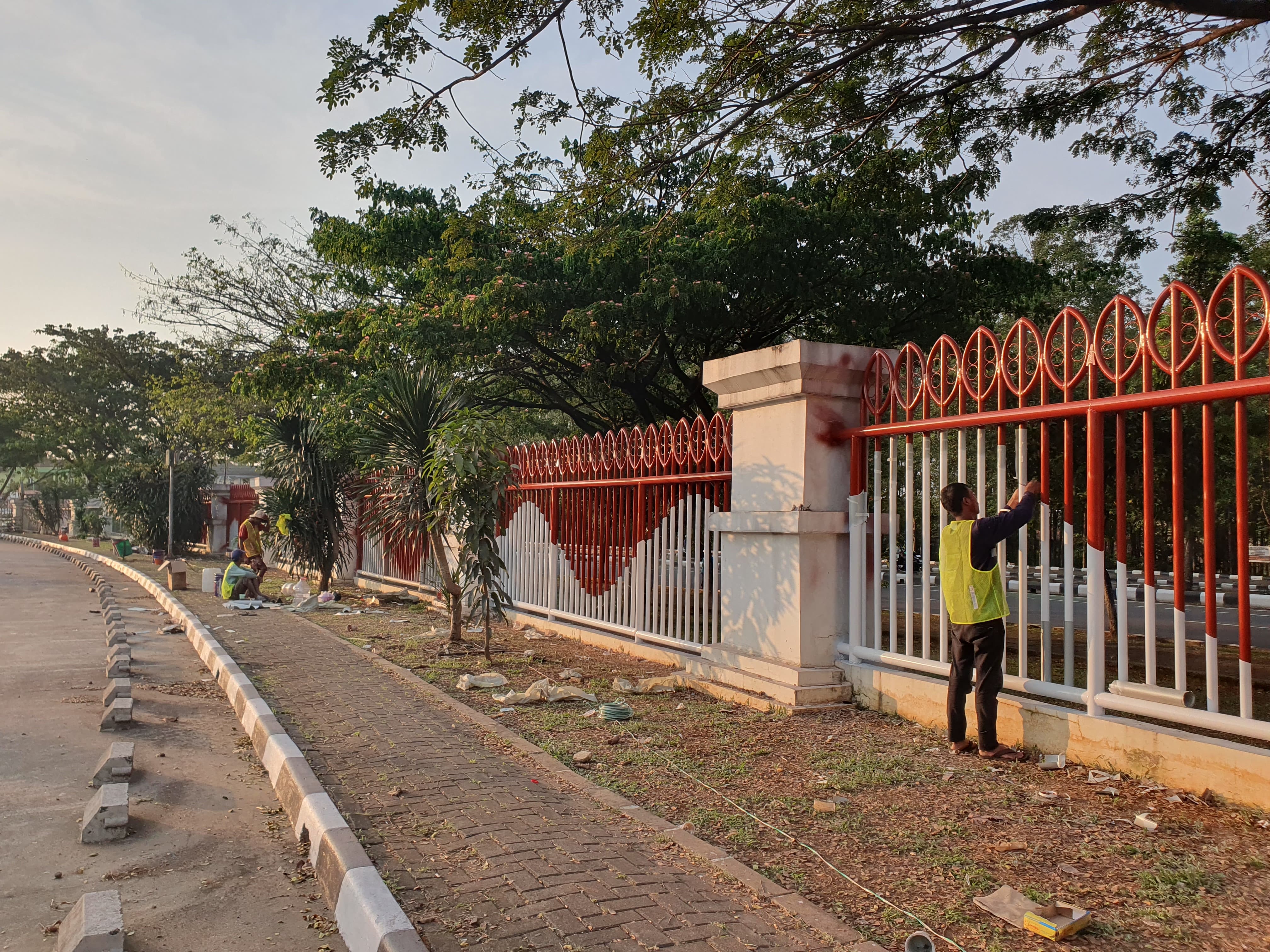 Pekerja saat mengecat pagar besi kawasan Stadion Pakansari, Kabupaten Bogor.
