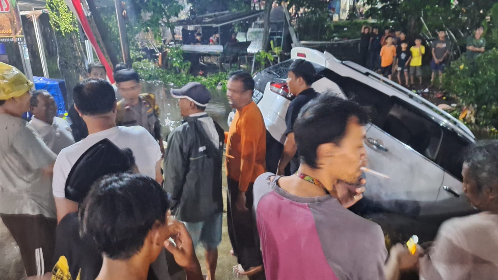 Warga berusaha mengevakuasi mobil terseret arus di Cimanggis, Kota Depok, Senin 11 Agustus 2025.