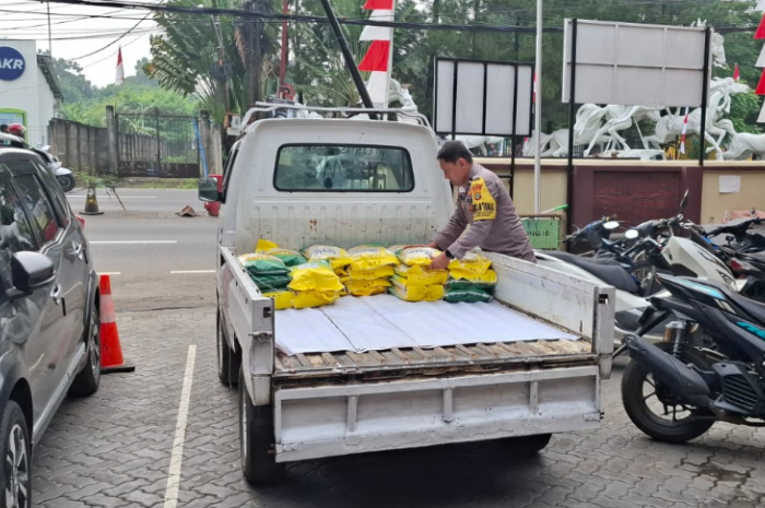 Polisi sedang mengangkut beras yang akan dijual dengan harga murah kepada masyarakat.
