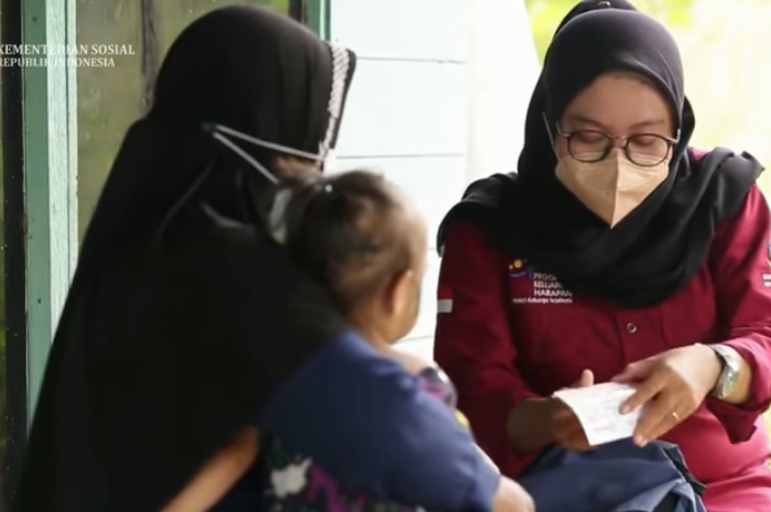 Pendamping sosial saat menjalankan tugas bertemu penerima bansos.