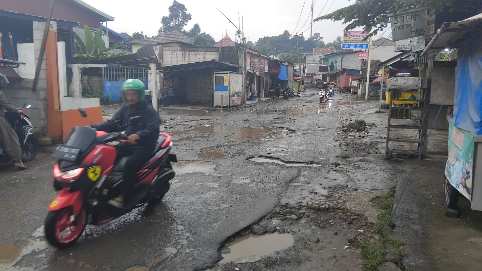 Kondisi jalan rusak di Kampung Tonggoh, Desa Tarikolot, Kecamatan Citeureup, Kabupaten Bogor, Kamis 14 Agustus 2025.