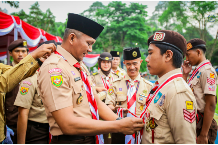 Jenal Mutaqin menyematkan Lencana Garuda kepada anggota Pramuka.