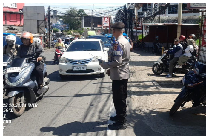 Polisi memastikan kelancaran arus lalu lintas di Jalan Raya Puncak, depan Pasar Cisarua.