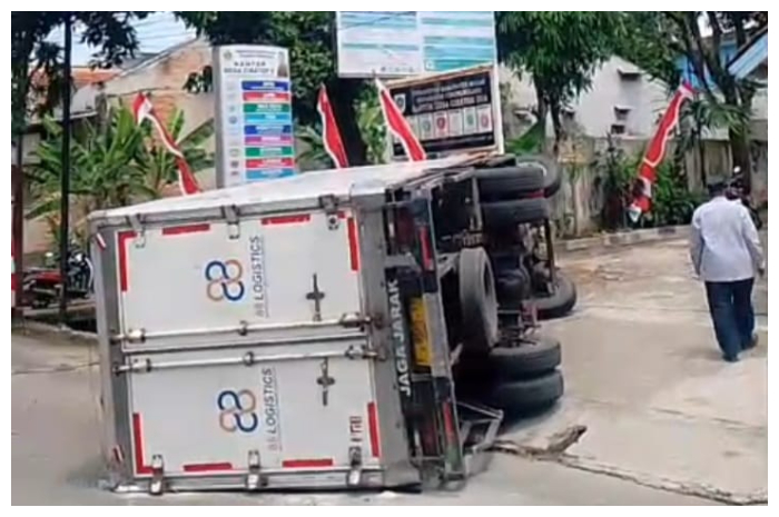 Truk bermuatan bansos beras terguling di depan Kantor Desa Cibatok II, Kecamatan Cibungbulang, Kamis 21 Agustus 2025.