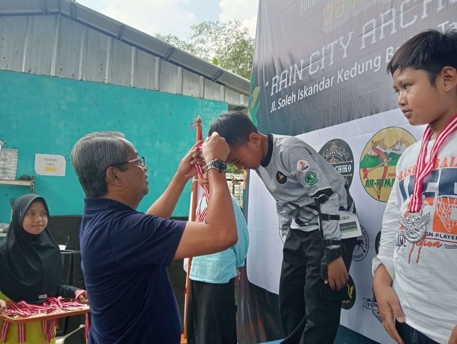 Ketua KORMI Kota Bogor, Zaenul Mutaqin mengalungkan medali kepada para pemenang kejuaraan panahan tradisional