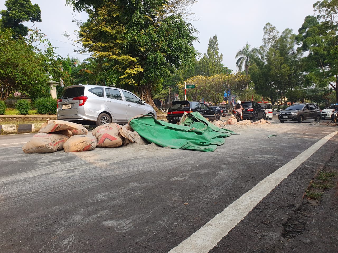 Puluhan sak semen dari atas truk berhamburan di Jalan Tegar Beriman, Kecamatan Cibinong, Kabupaten Bogor, Selasa 26 Agustus 2025.