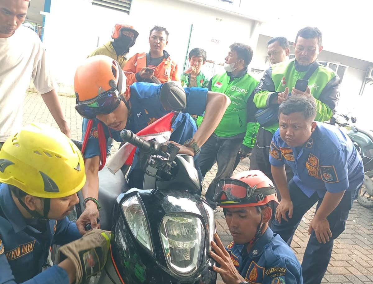 Damkar Depok evakuasi ular kobra yang bersarang di dalam motor pengemudi ojol.