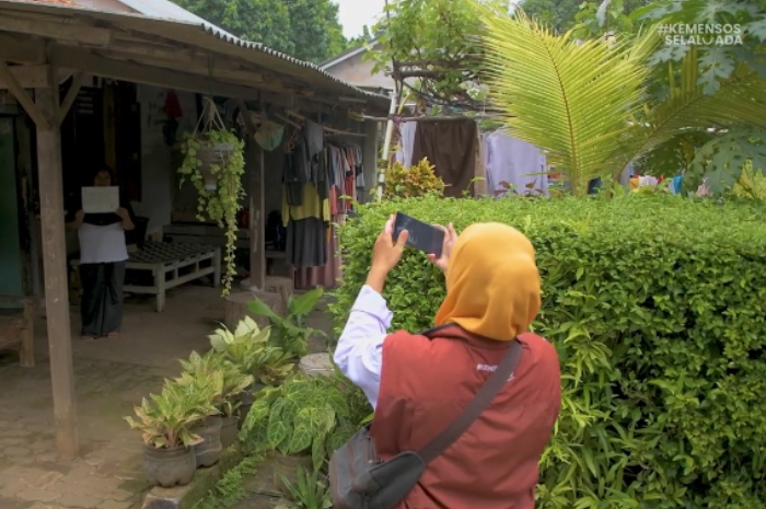 Petugas pendamping sosial saat mengecek rumah penerima bansos.