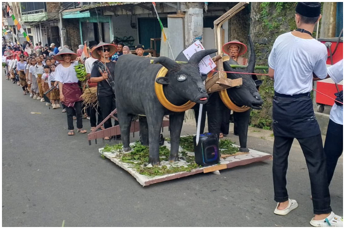 Salah satu rombongan konvoi warga Desa Suukamanah  dengan dongdang berupa miniatur sapi.