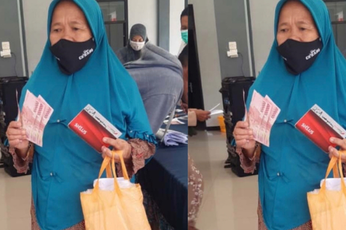 Penerima Bansos memperlihatkan uang.