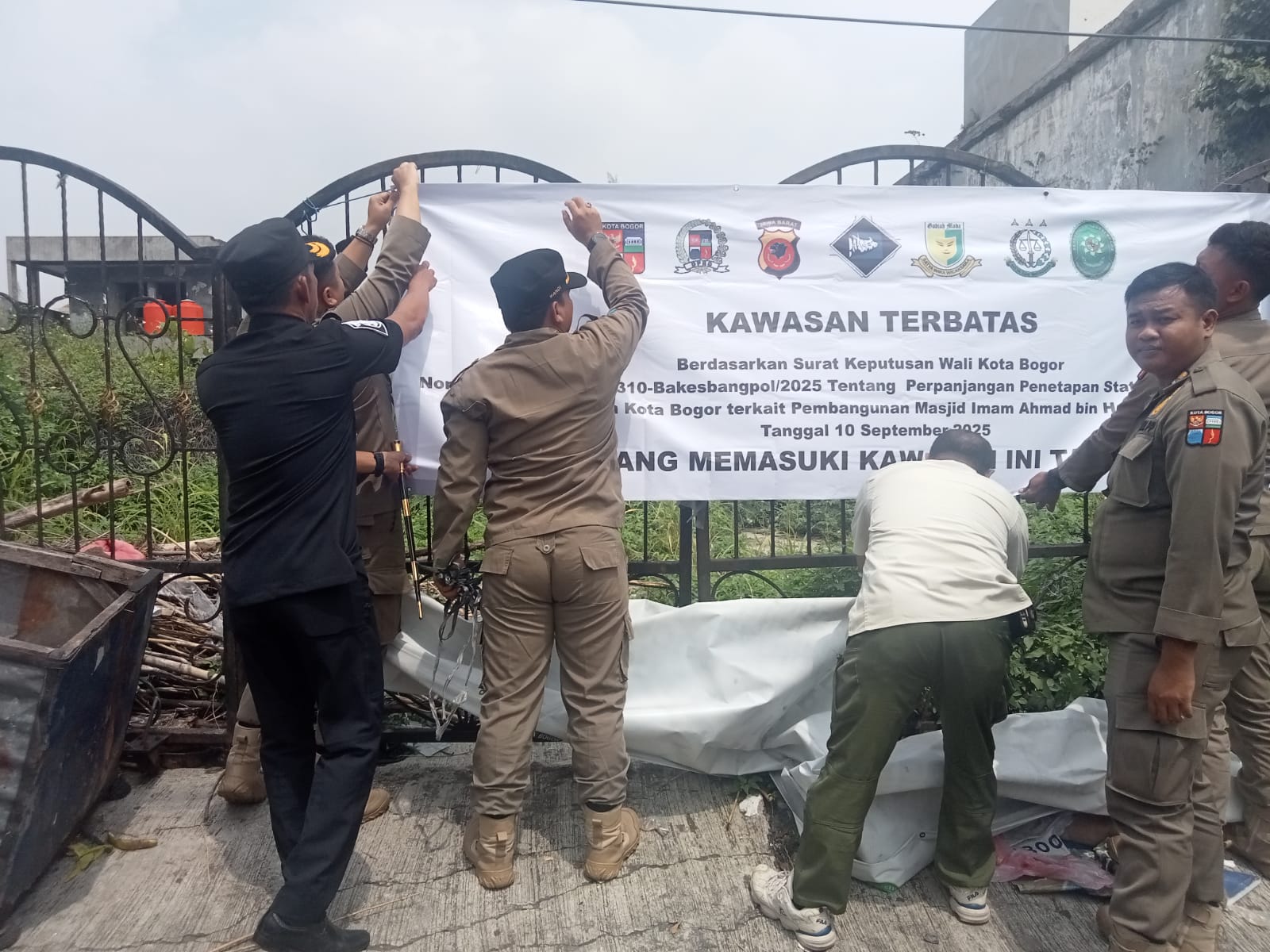 Perpanjangan status ditandai dengan pemasangan spanduk oleh Plt Kasatpol PP Kota Bogor, Rahmat Hidayat, bersama unsur wilayah.