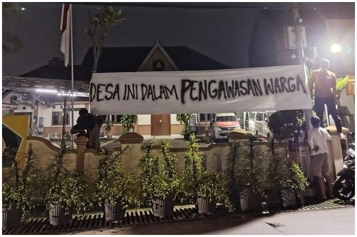 Warga memasang spanduk bertuliskan &ldquo;Desa Ini Dalam Pengawasan Warga&rdquo; di depan kantor Desa Bojong Kulur, Kecamatan Gunung Putri, Kabupaten Bogor.