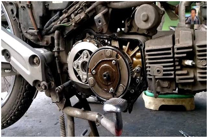 Ilustrai  proses turun mesin motor saat menjalani perbaikan komponen internal di bengkel.
