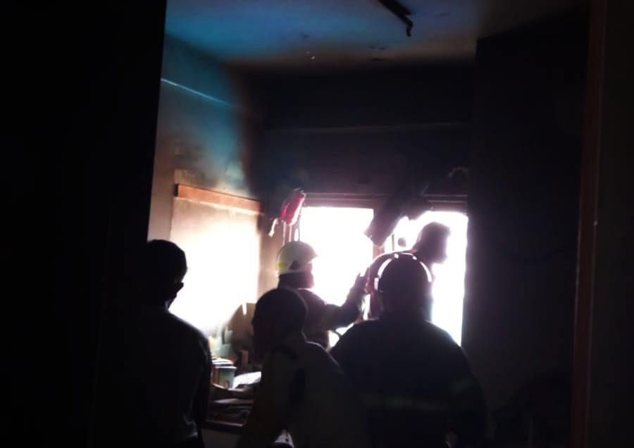 Petugas damkar Kota Depok melakukan pemadaman di unit apartemen yang terbakar.