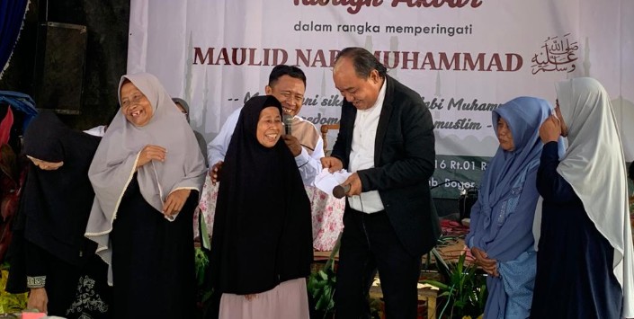 Aziz Gagap saat membagikan uang kepada ibu-ibu lanjut usia di acara Maulid Nabi Muhammad SAW