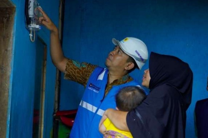 Petugas PLN melihat sambungan listrik salah satu warga Jawa Barat.