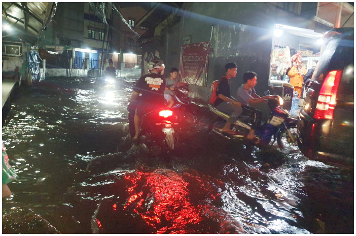 Pengendara saat melewati banjir di Jalan Mayor Oking tepatnya di Gang Golf, Ciriung, Kecamatan Cibinong, Kabupaten Bogor.